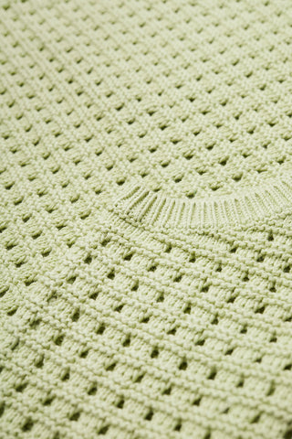Close-up of green sleeveless crochet Arch Vest by Kloke. 