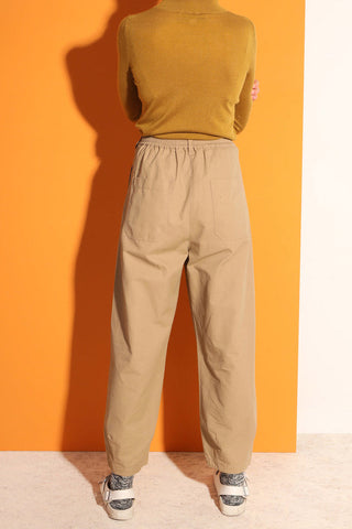 Back view of model wearing camel cotton twill pleated LF Markey Jenkin pants. 