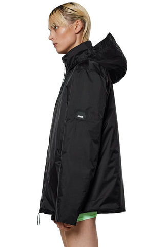 Side view of model wearing black insulated waterproof RAINS Fuse jacket. 