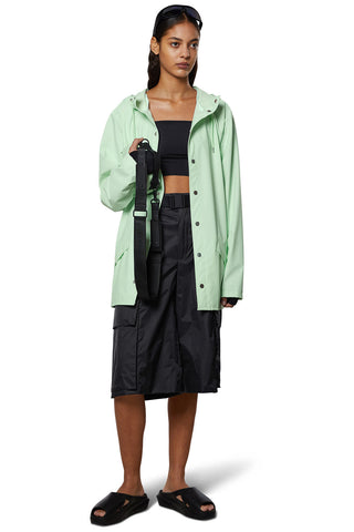 Model wearing (mineral) green unisex RAINS rain jacket.