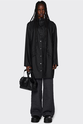 Model wearing unisex RAINS Long Jacket in black. 