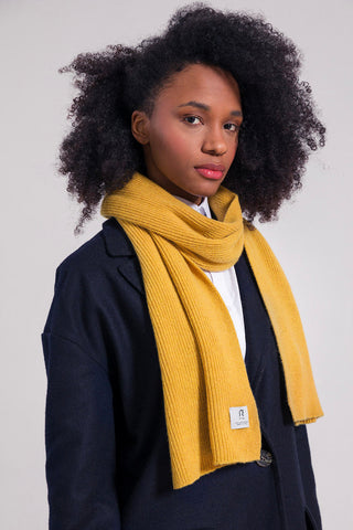 Model wearing yellow recycled cashmere Frederico scarf by Rifo. 