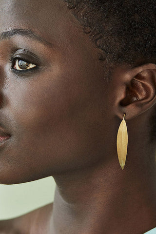 Model wearing Soko Jani Threader earring in gold. 