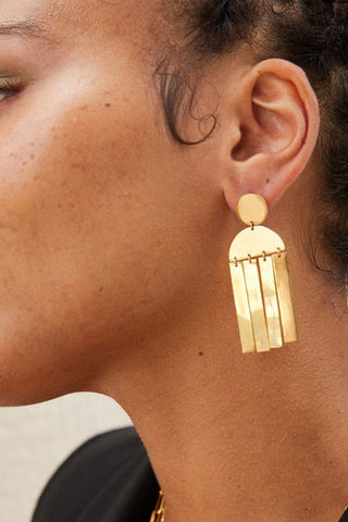 Model wearing Soko Maxi Cala Earrings in gold. 