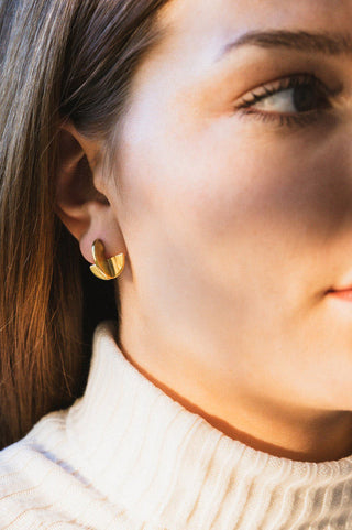 Model wearing gold plated Crescent stud earrings by Tilly D'oro.