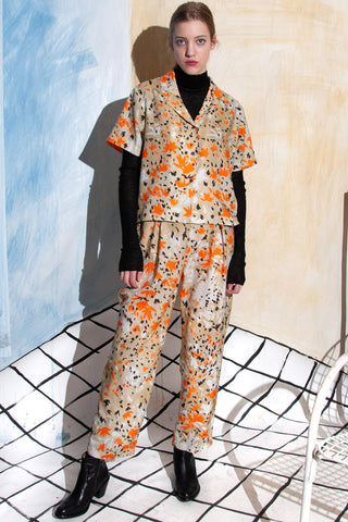 Model wearing orange and black printed tencel Tempter pants by Untitled in Motion. 