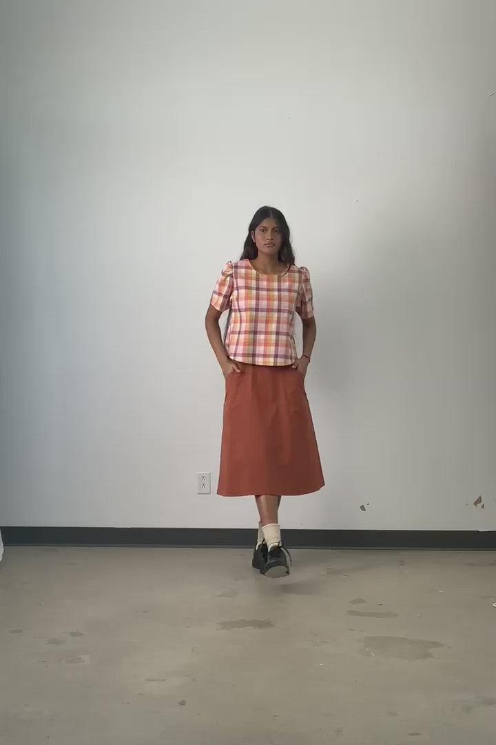 Video of model wearing Jennifer Glasgow Samudra pink plaid blouse in GOTS certified organic cotton. 